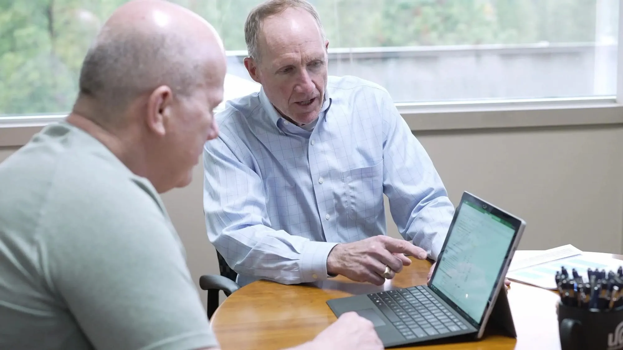 Financial advisor reviewing a plan with a client at a laptop