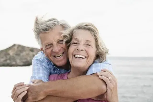 Retired couple smiling together by the ocean