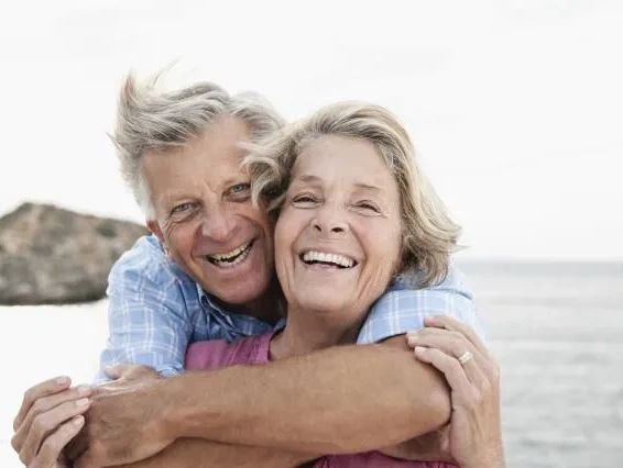 Retired couple smiling together by the ocean