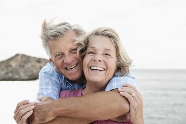 Retired couple smiling at the ocean