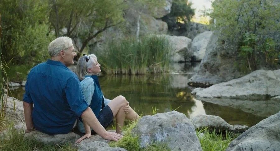 Retired couple sitting by a lake