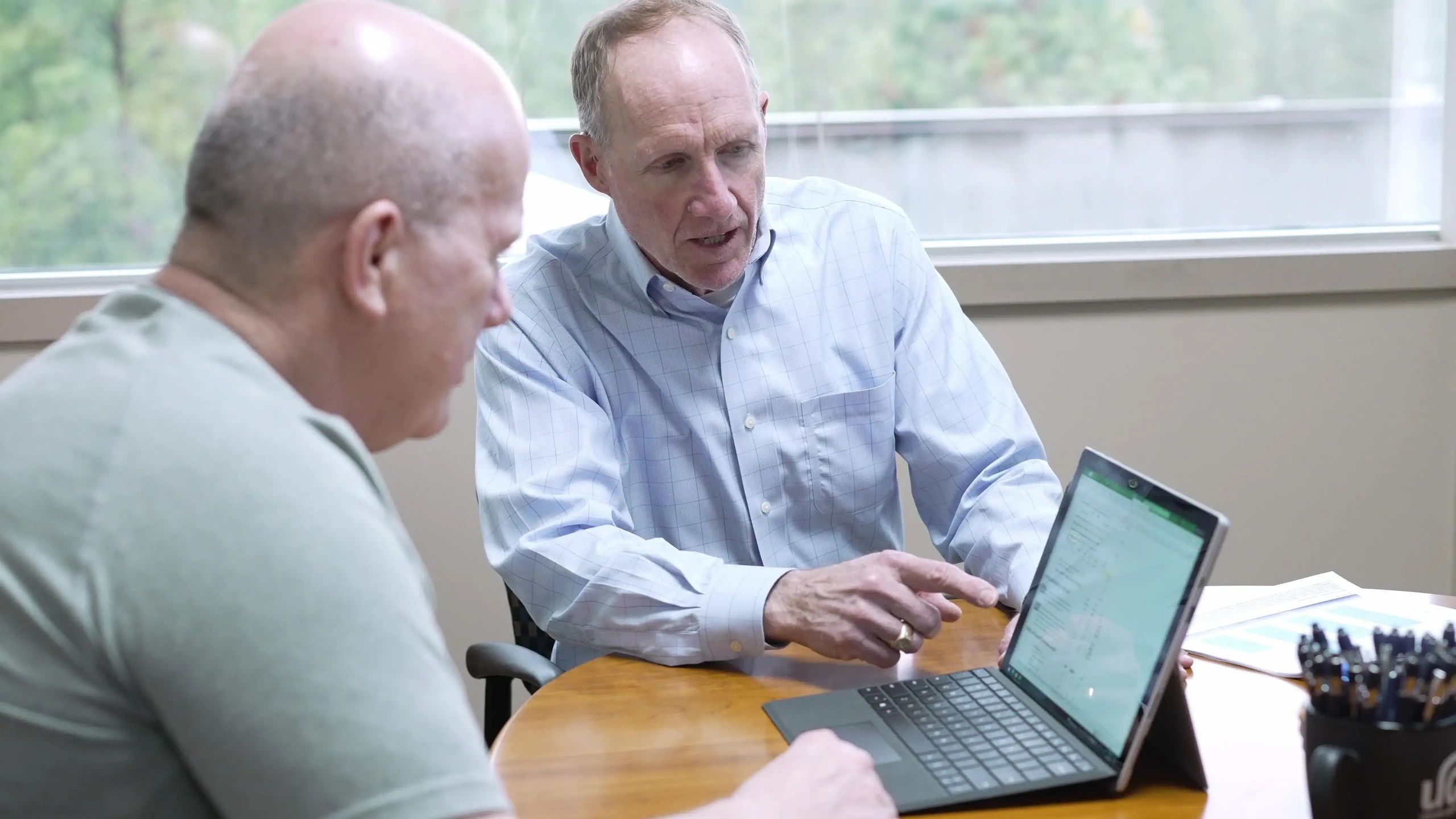 Financial advisor reviewing a plan with a client at a laptop